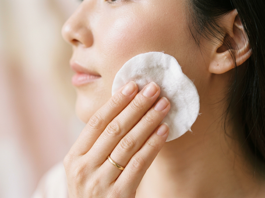 Applying an AHA exfoliating toner with a cotton pad